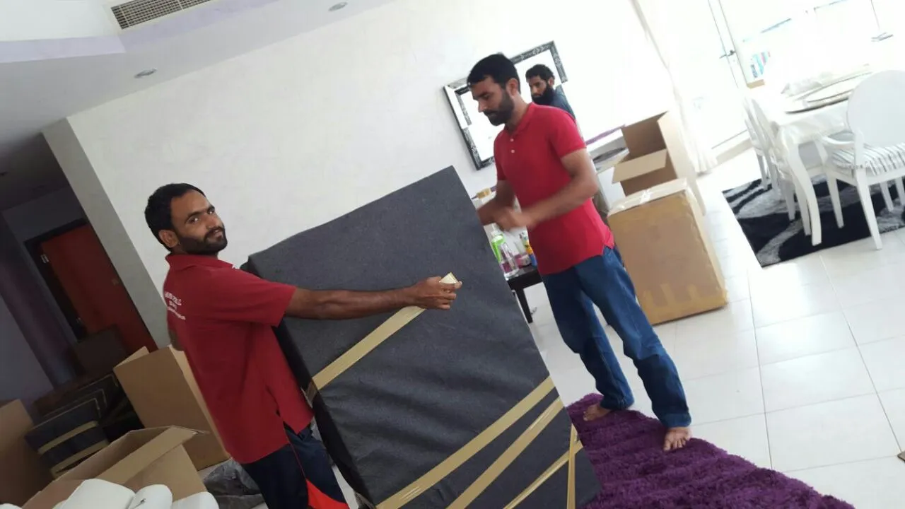 Expert Movers team wrapping and packing furniture during an overnight Abu Dhabi move